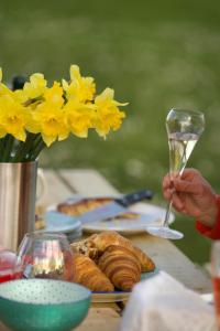 a table with a plate of food and a glass of wine at Dilham Hall Retreats in Dilham