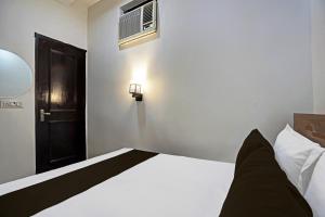 a bedroom with a white bed and a black door at OYO Kiiza Stay House in New Delhi