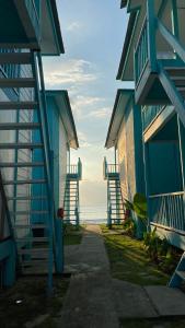 a blue building with stairs next to the ocean at Pondok Beach Shack in Tioman Island