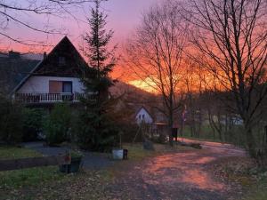 a house with a sunset in the background at Gasthof Walhalja in Schmallenberg