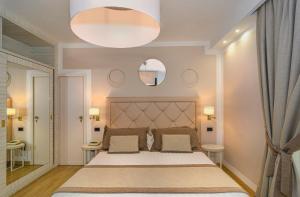 sypialnia z dużym łóżkiem i lustrem w obiekcie Raffaelli Park Hotel w mieście Forte dei Marmi