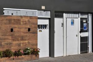 two white doors are next to a wall with flowers at 54 LOFT quadruplo · LOFT, apartamento, pousada perto Sao Paulo EXPO in Sao Paulo