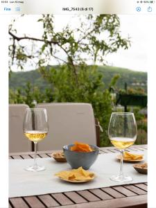 a table with two glasses of wine and a bowl of chips at VITEDIMARE APARTMENT SABBIA - SAND in Muggia +28 photos
