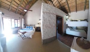 a room with two beds and two tables in it at River House Lodge in Malelane