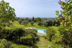 une piscine dans un jardin avec des arbres et un champ dans l'établissement Antiche Mura, à Barberino di Val dʼElsa