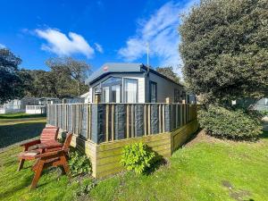 una pequeña casa con terraza y banco en Beautiful Caravan With Decking And Wifi At Azure Sea, Suffolk Ref 32025az en Lowestoft