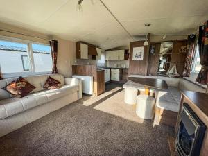 ein Wohnzimmer mit einem Sofa und einer Küche in der Unterkunft Lovely 8 Berth Caravan At California Cliffs Nearby Scratby Beach Ref 50060e in Great Yarmouth