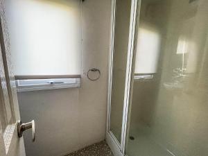 La salle de bains est pourvue d'une douche et d'une porte en verre. dans l'établissement Lovely 8 Berth Caravan At California Cliffs Nearby Scratby Beach Ref 50060e, à Great Yarmouth