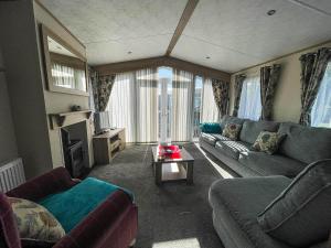 sala de estar con sofá y mesa en Beautiful Caravan With Decking And Wifi At Azure Sea, Suffolk Ref 32025az en Lowestoft