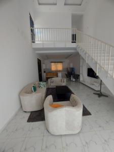 a living room with two couches and a staircase at Jamiitown Homes in Kilifi