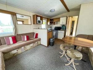 a living room with a couch and a table and a kitchen at 8 Berth Caravan At Dovercourt Holiday Park In Essex Ref 44002p in Great Oakley