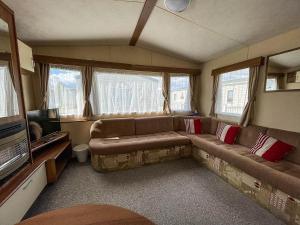 a living room with a couch and a tv at 8 Berth Caravan At Dovercourt Holiday Park In Essex Ref 44002p in Great Oakley