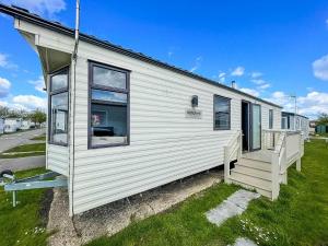 a white mobile home with a porch and windows at 6 Berth Caravan With Free Wi-fi At Dovercourt Holiday Park In Essex Ref 44009c in Great Oakley