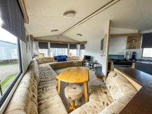 a living room with a couch and a table at 6 Berth Caravan With Free Wi-fi At Dovercourt Holiday Park In Essex Ref 44009c in Great Oakley