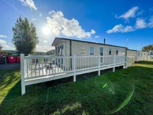 a mobile home with a white fence at Lovely 6 Berth, Dog Friendly Caravan For Hire In Norfolk Ref 50011ae in Great Yarmouth