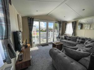 a living room with a couch and a tv at Lovely 6 Berth, Dog Friendly Caravan For Hire In Norfolk Ref 50011ae in Great Yarmouth