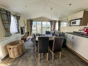 a kitchen and living room with a table and chairs at Lovely 6 Berth, Dog Friendly Caravan For Hire In Norfolk Ref 50011ae in Great Yarmouth