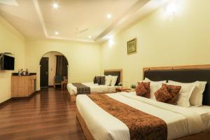 a hotel room with two beds and a television at Hotel SunGrace in Mussoorie