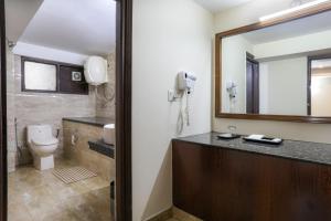 bagno con lavandino, servizi igienici e telefono di Hotel SunGrace a Mussoorie
