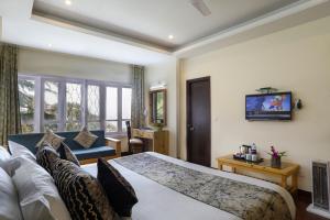 Hotel SunGrace في موسوري: غرفه فندقيه بسرير واريكه
