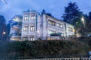 a white house on top of a hill at Hotel SunGrace in Mussoorie