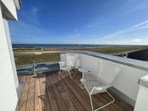 2 sillas y una mesa en un balcón con vistas al océano en Ferienwohnung Steuerbord, en Kalifornien