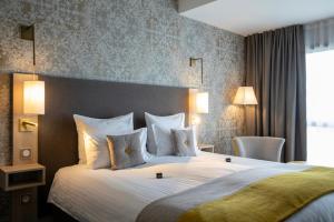 Habitación de hotel con cama grande con almohadas blancas en James Boutique Hôtel Colmar centre en Colmar