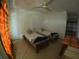 a bedroom with two beds and a ceiling fan at DEEP SEA RESORT PADI DIVE CENTER in Batticaloa