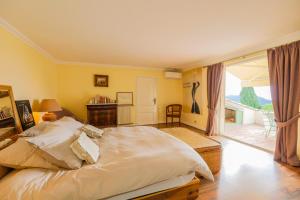 - une chambre avec un grand lit et un balcon dans l'établissement LOU MAS SOUBRAN VI2083 by RIVIERA HOLIDAY HOMES, à Nice