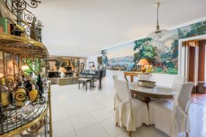 LOU MAS SOUBRAN VI2083 by RIVIERA HOLIDAY HOMES في نيس: مطبخ وغرفة طعام مع طاولة وكراسي