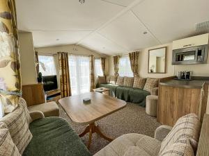 een woonkamer met banken en een tafel bij Gorgeous 6 Berth Caravan With Decking Area, Dovercourt Holiday Park Ref 44010af in Great Oakley