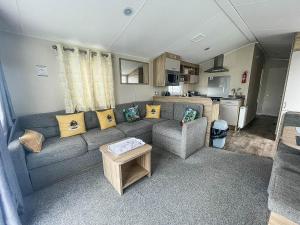 salon z kanapą i kuchnią w obiekcie Gorgeous Caravan With Decking And Wi-fi At Carlton Meres In Suffolk Ref 60059fw w mieście Saxmundham