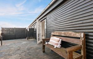 a wooden bench sitting on a deck next to a building at 3 Bedroom Lovely Home In Saltum in Saltum