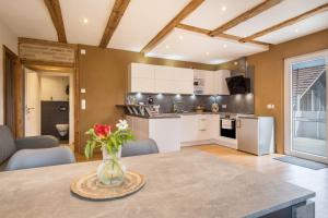 a kitchen with a table with a vase of flowers at Ferienwohnung Lang in Kressbronn am Bodensee