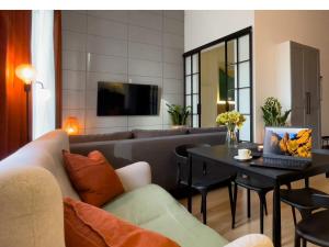 un soggiorno con un divano e un tavolo con un computer portatile di URBAN APARTMENTS PREMIUM, Sokolska 30 Towers No 3, Free Parking, Gym & Sauna, Self Check-in a Katowice