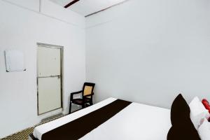BulandshahrにあるSPOT ON Hotel T Townのベッドルーム1室(ベッド1台、椅子、窓付)