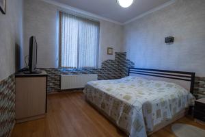 a bedroom with a bed and a flat screen tv at Sevan Private Guest House in Sevan
