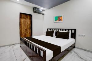 Schlafzimmer mit einem Bett mit weißen Wänden in der Unterkunft OYO Hotel Ambika in Vadodara