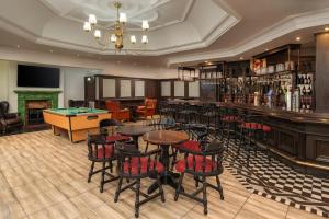 a bar with tables and chairs and a pool table at Holiday Inn - Johannesburg Sunnyside Park, an IHG Hotel in Johannesburg