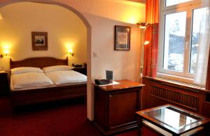 una camera con letto, scrivania e finestra di Soldanella a Sankt Moritz