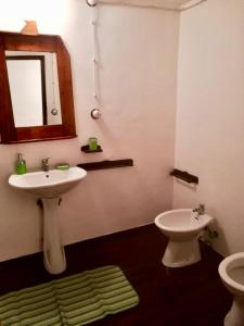 a bathroom with a sink and a toilet and a mirror at Case Rurali Pentedattilo in Pentedattilo