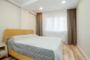1 dormitorio con cama y ventana en Oază Urbană lângă Circ și Centru - Apartament Modern și Confortabil en Chisináu