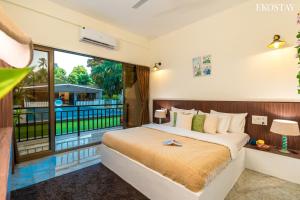 a bedroom with a bed and a large window at Ekostay Gold Sea Shore Villa I Rooftop Turf I 100 Meters away from the Beach in Alibaug