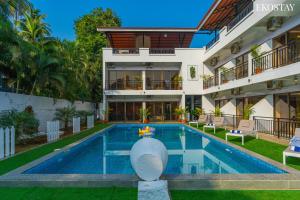 an exterior view of a building with a swimming pool at Ekostay Gold Sea Shore Villa I Rooftop Turf I 100 Meters away from the Beach in Alibaug