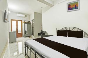 1 dormitorio con 1 cama blanca grande y 1 silla en OYO Pravin Guest House, en Goa