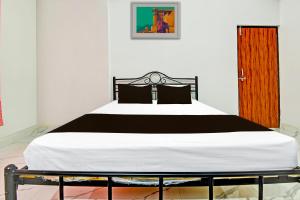 1 dormitorio con 1 cama con edredón blanco y negro en OYO Pravin Guest House, en Goa