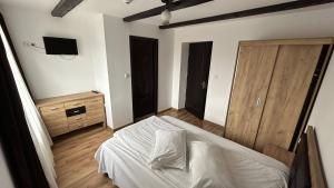 a bedroom with a bed and a wooden door at Hotel Intim in Rădăuţi