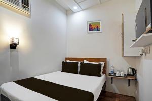 a bedroom with a bed in a white room at OYO Kiiza Stay House in New Delhi