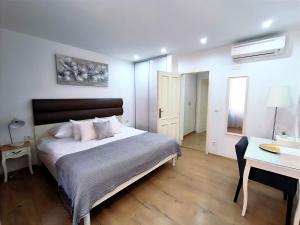 ein Schlafzimmer mit einem großen Bett und einem Schreibtisch sowie einem Bett von sidx sidx sidx sidx sidx in der Unterkunft Rialto Luxury Apartment in Šibenik