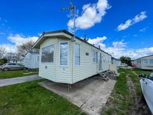 a tiny house is parked in a yard at Great 8 Berth Caravan With Wifi At Dovercourt Holiday Park In Essex Ref 44003c in Great Oakley
